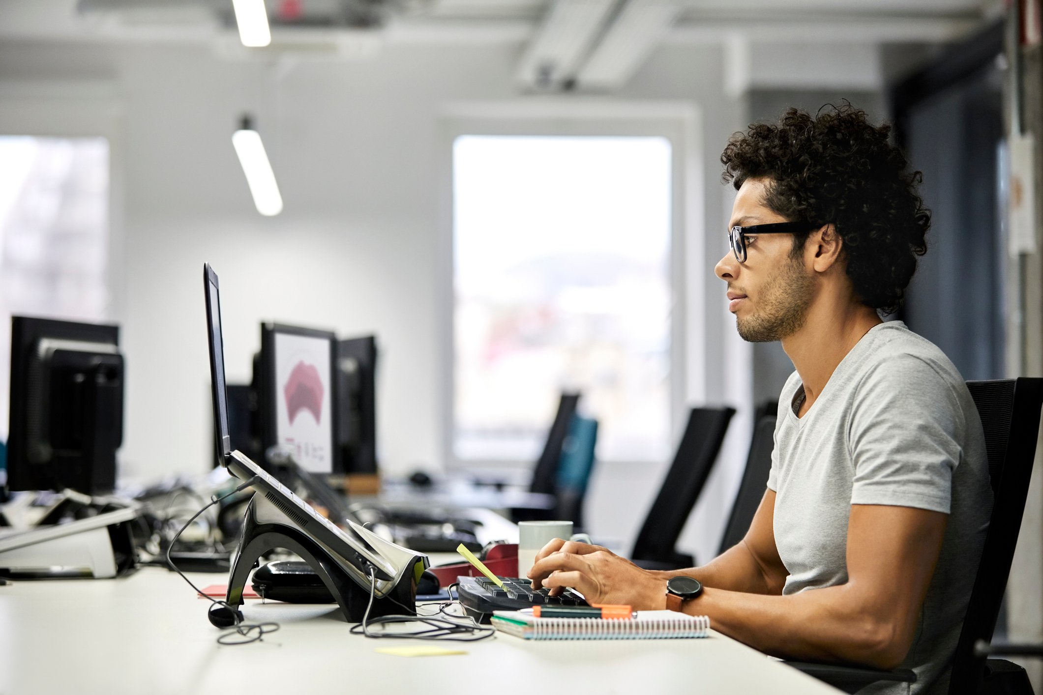 A tech worker uses a desktop computer at an office.