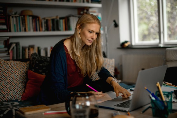 Woman with pencil looking at computer