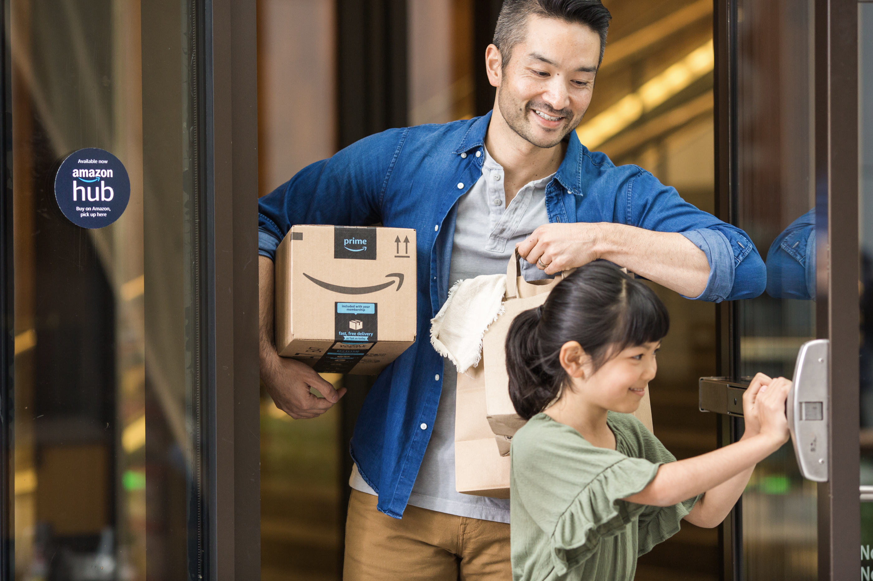 An Amazon customer carrying a delivery box.
