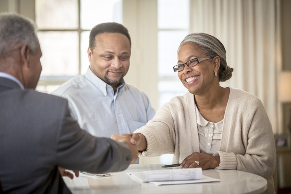 A couple shaking hands with an advisor.