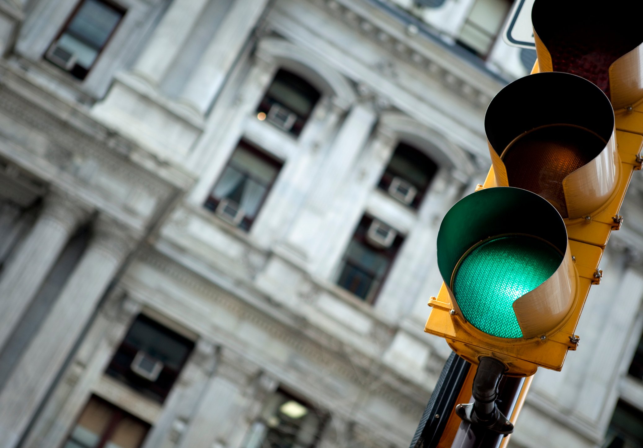 Traffic light in an urban environment showing green.