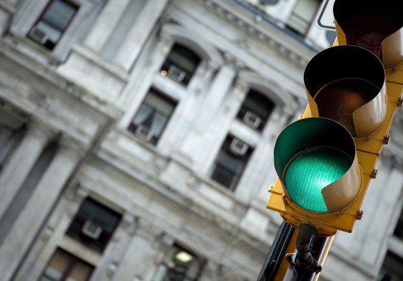 Traffic light in an urban environment showing green.