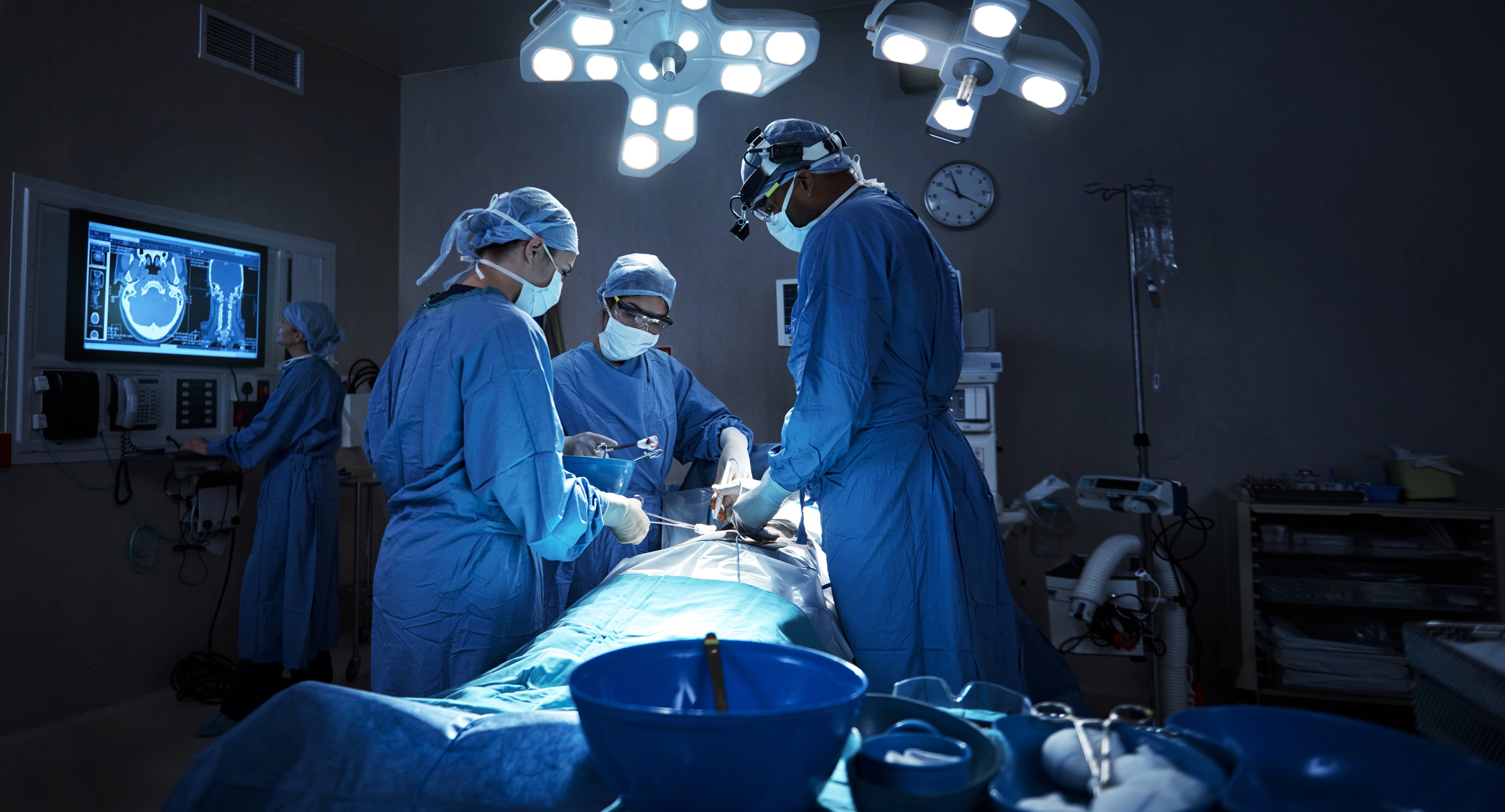 A team of surgeons performs surgery on a patient in the operating room.