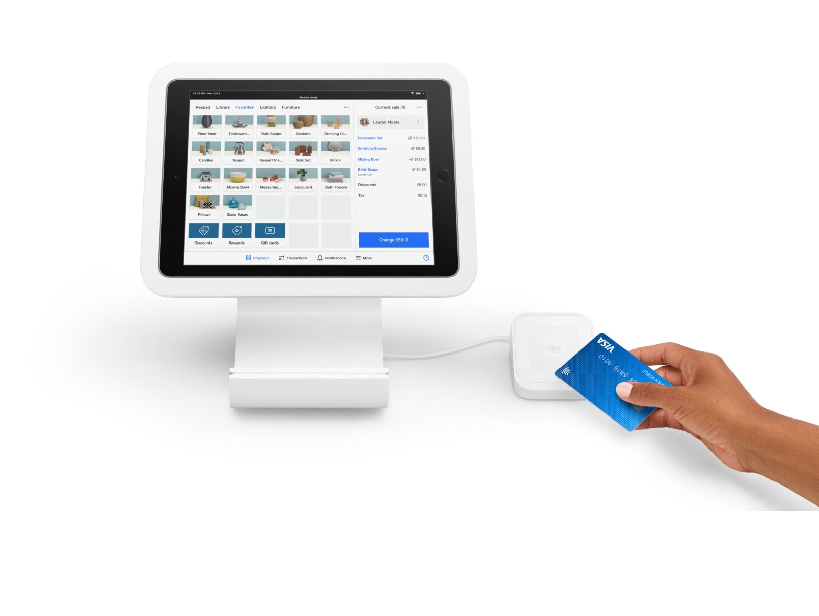 Hand with card over reader, with iPad nearby.