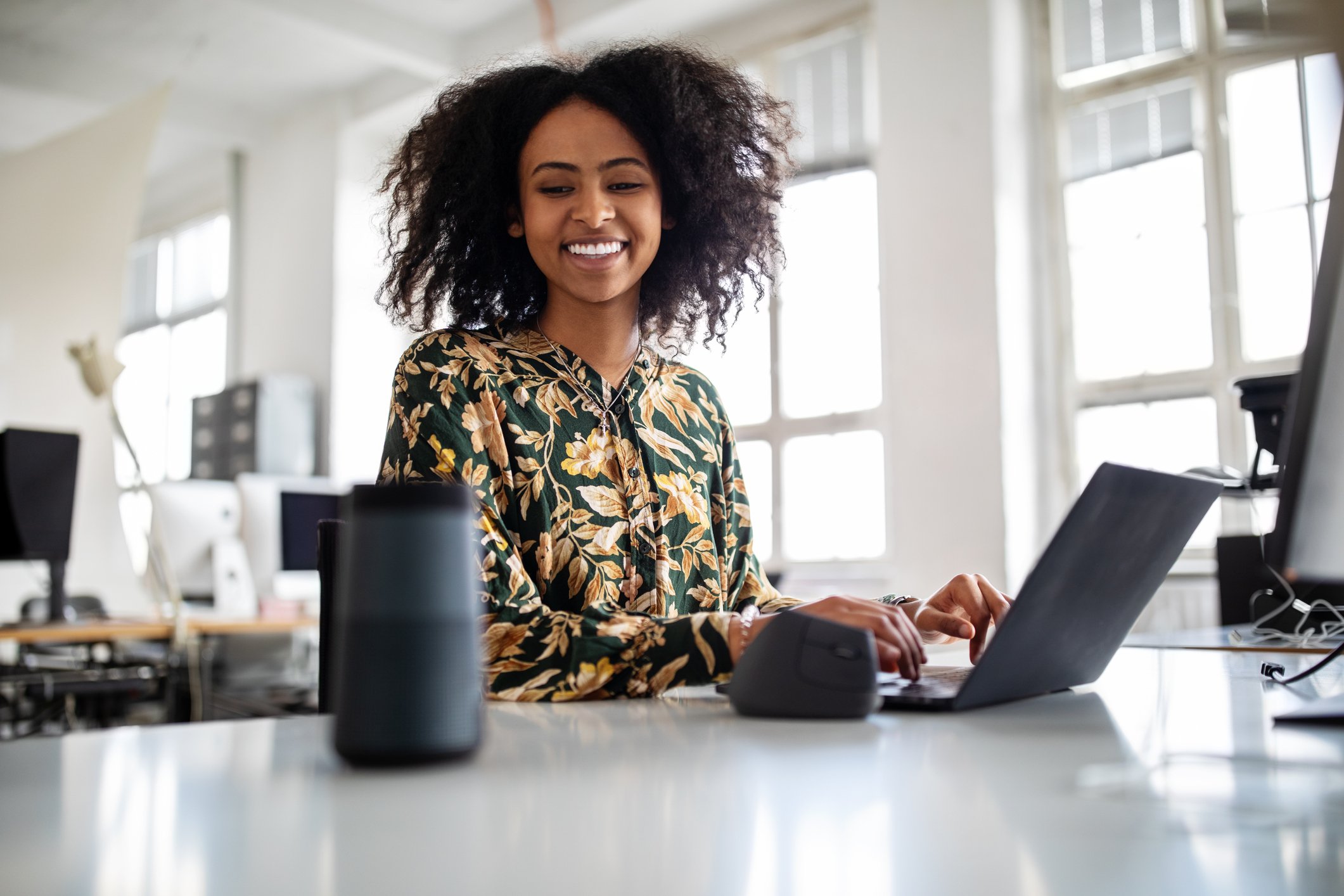 Worker communicates with a smart speaker at an office.