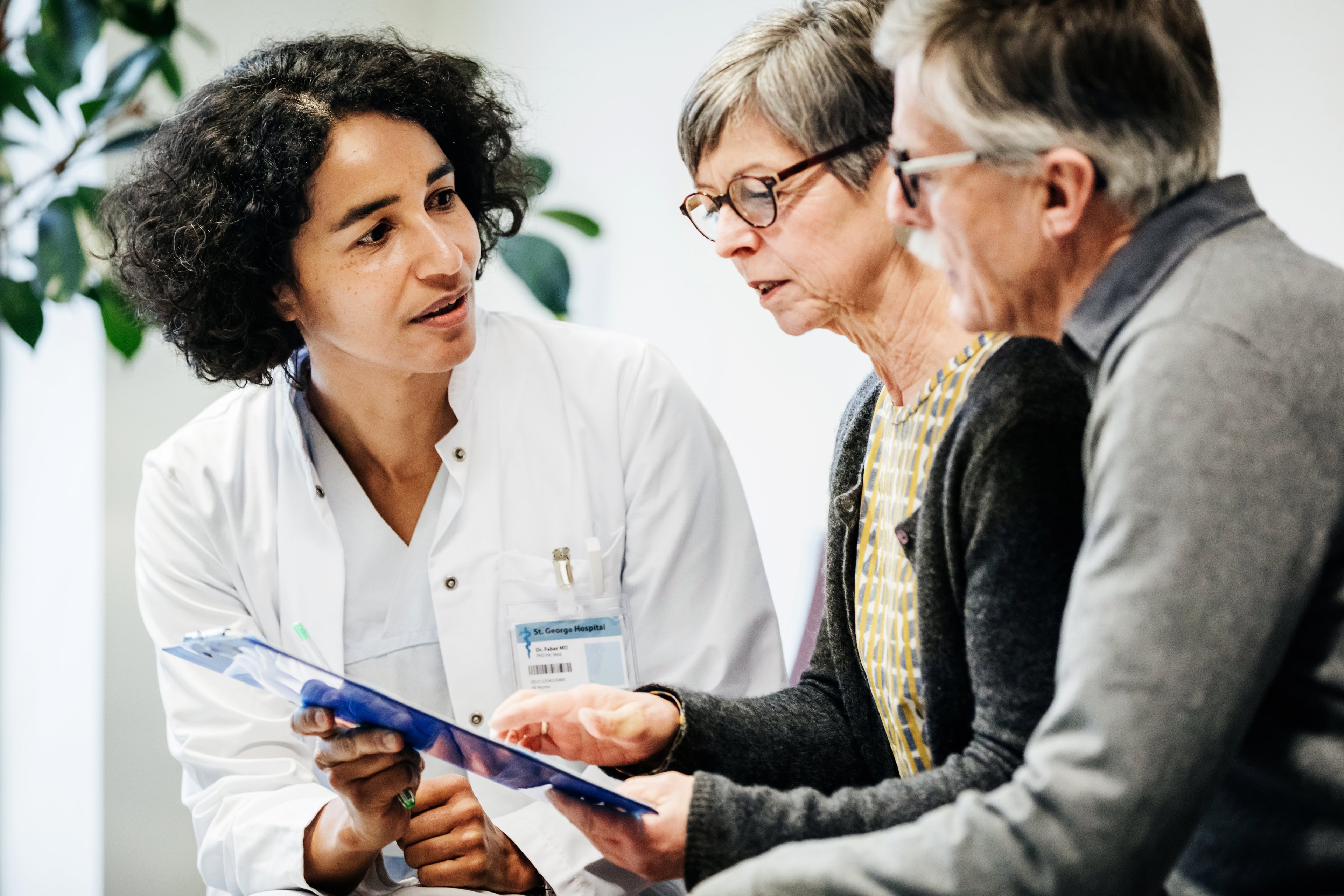 Doctor holding paperwork in front of patients. 