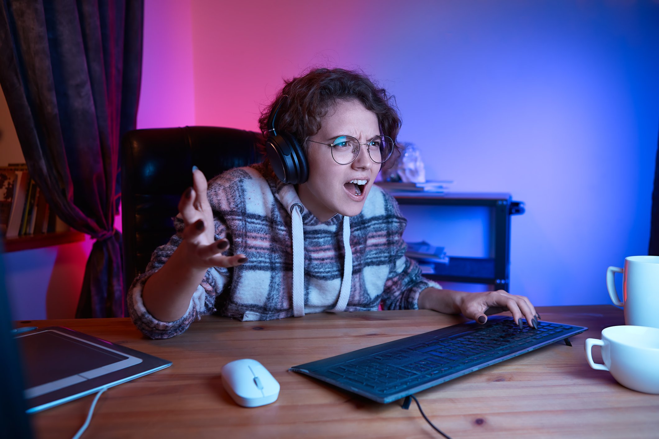 An upset computer user waving a hand at the screen.