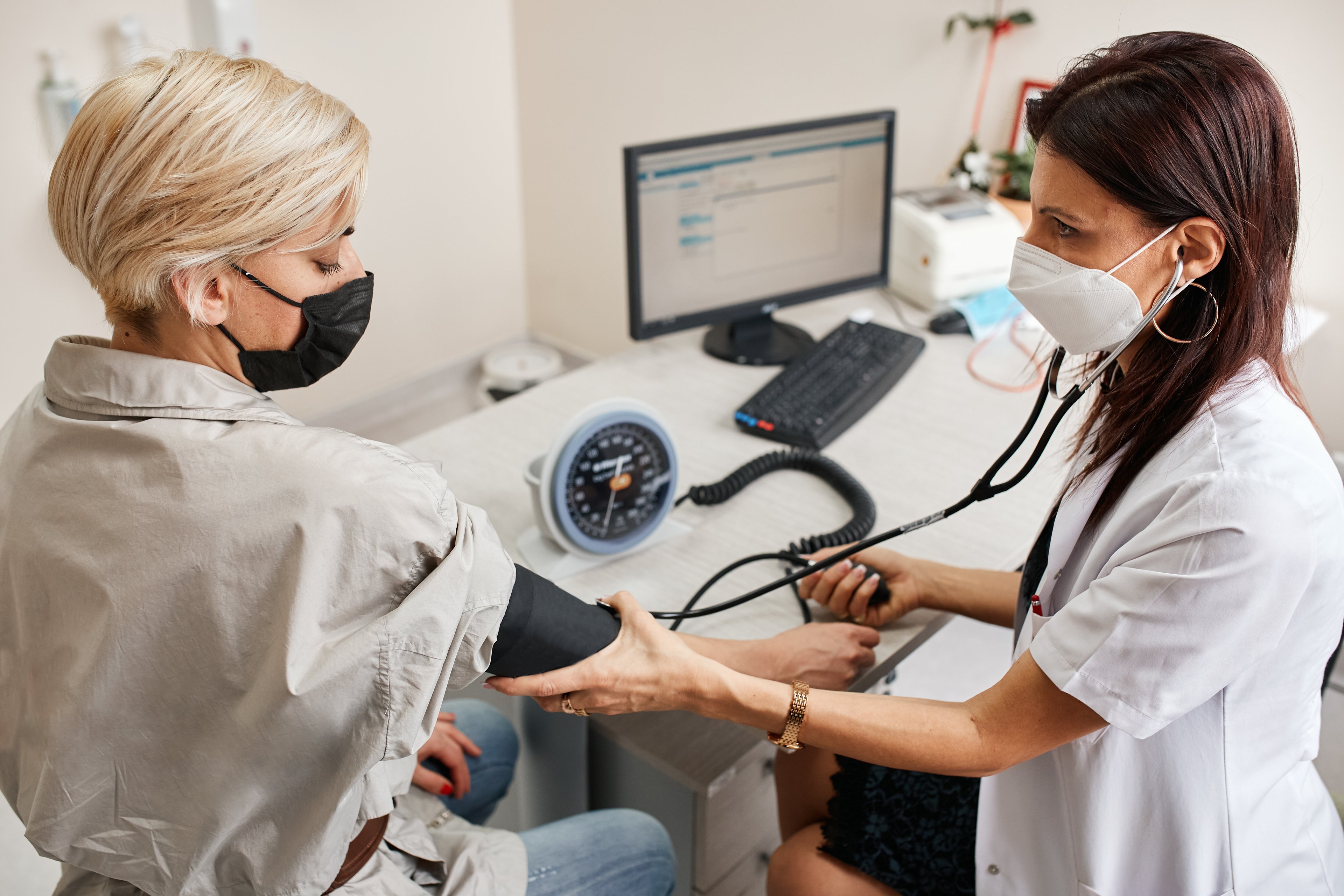 A healthcare worker takes a patient's blood pressure.