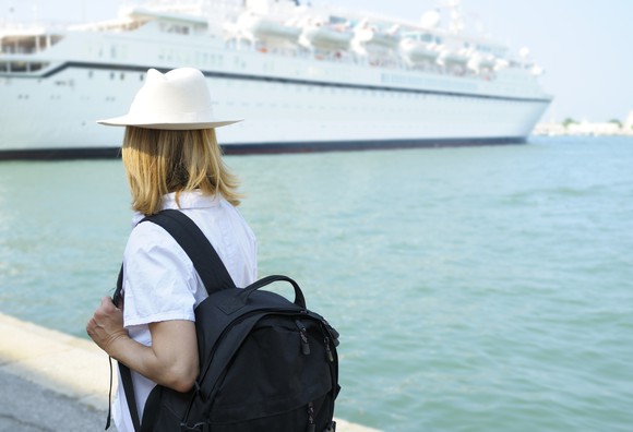 Passenger with a backpack waits for a cruise ship.