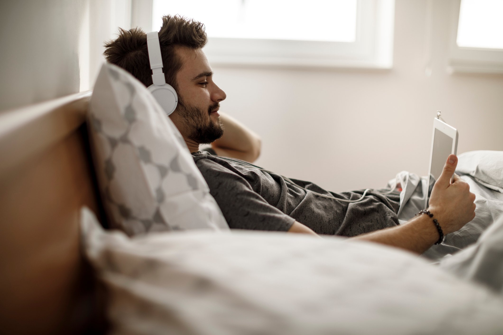 A person in bed watching something on an electronic device. 