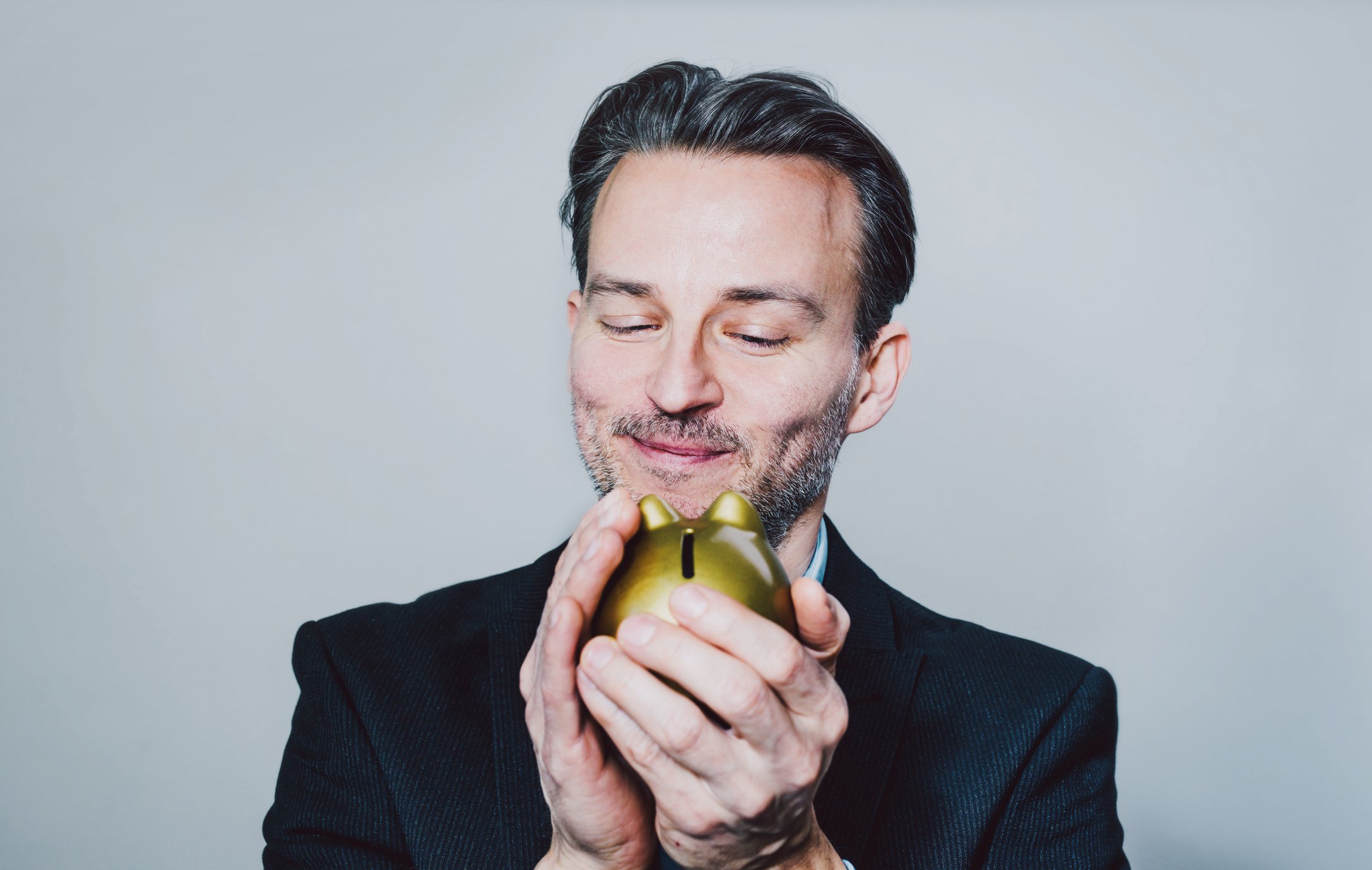Person holding a golden piggy bank.