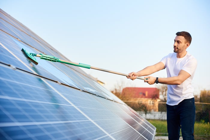 Person cleaning a solar panel.