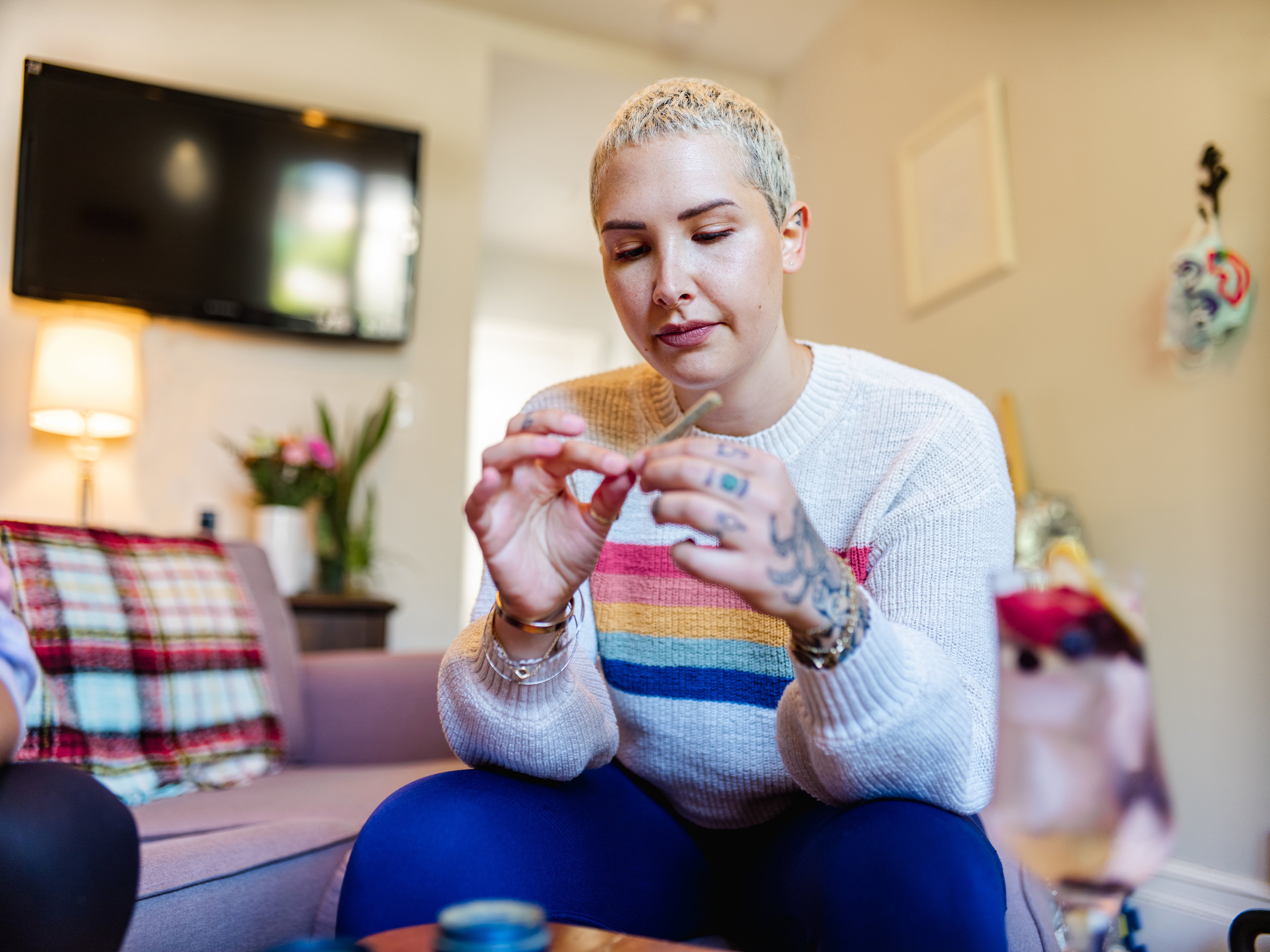 A person rolling a marijuana cigarette at home. 