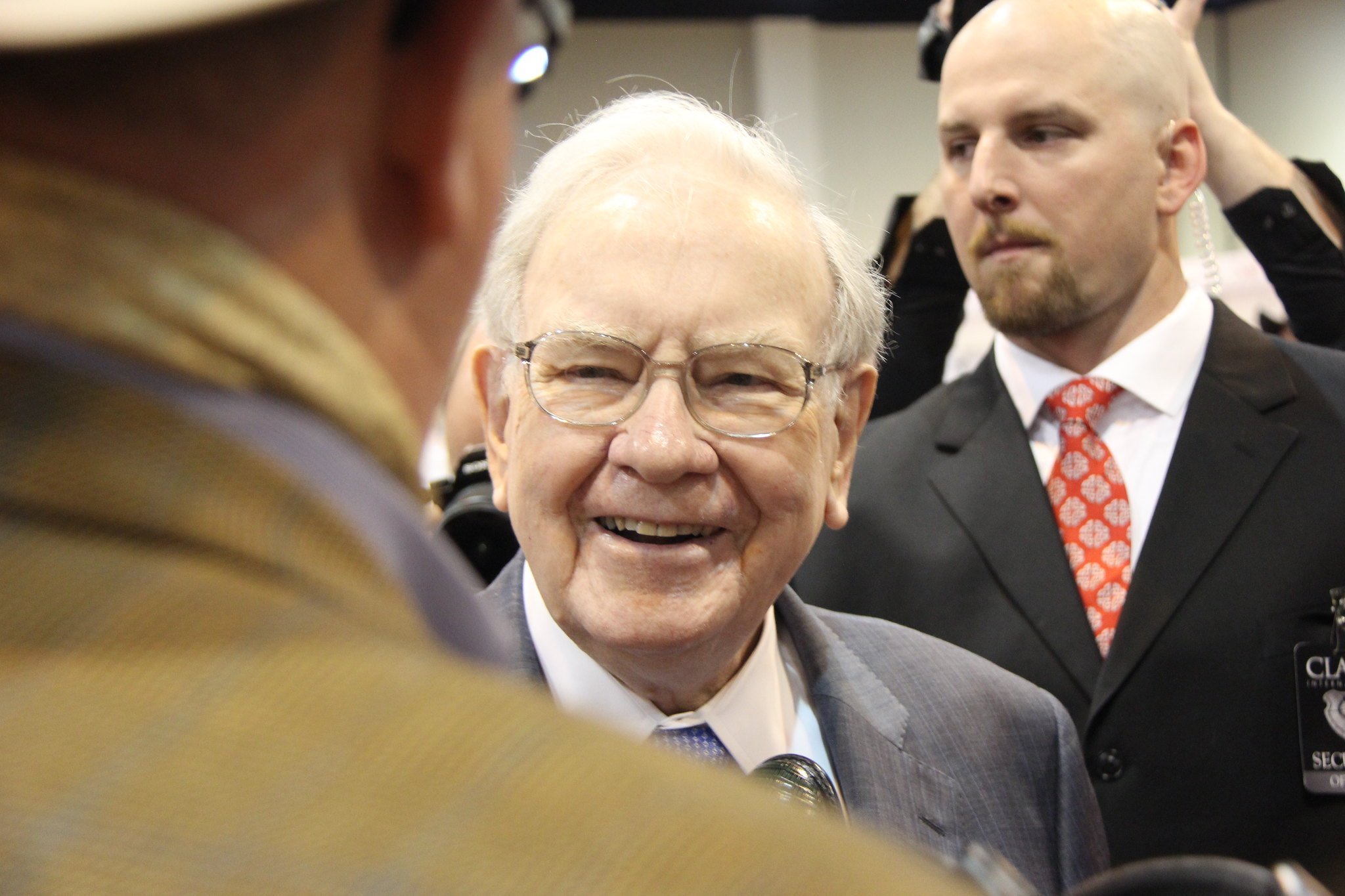 Warren Buffett holding a conversation at a large event.