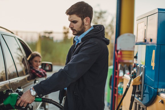 A person refueling a car at a gas station.
