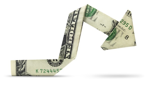 A dollar bill, folded origami-style into a charting arrow pointing down.