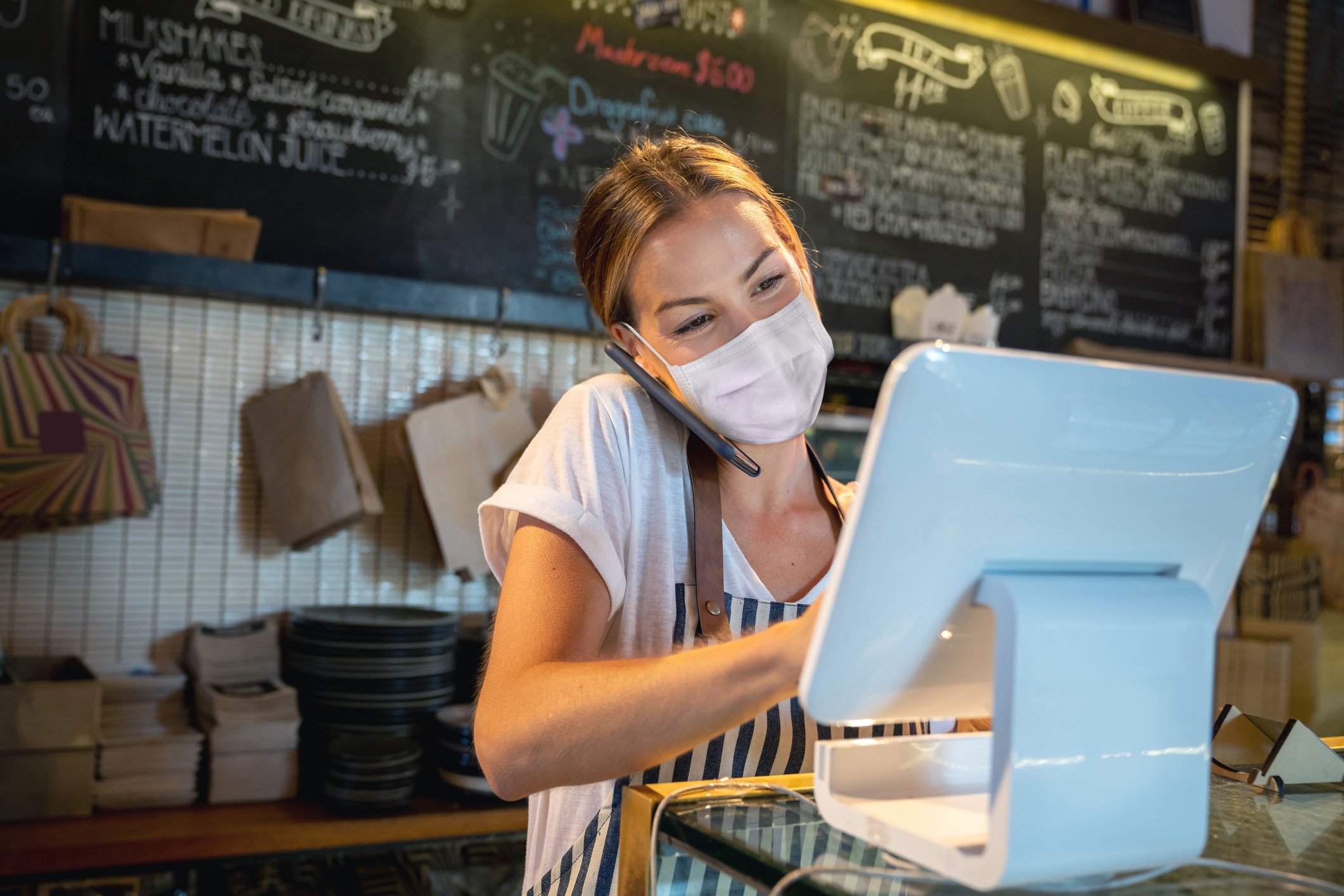 Barista processes a transaction at a coffee shop.