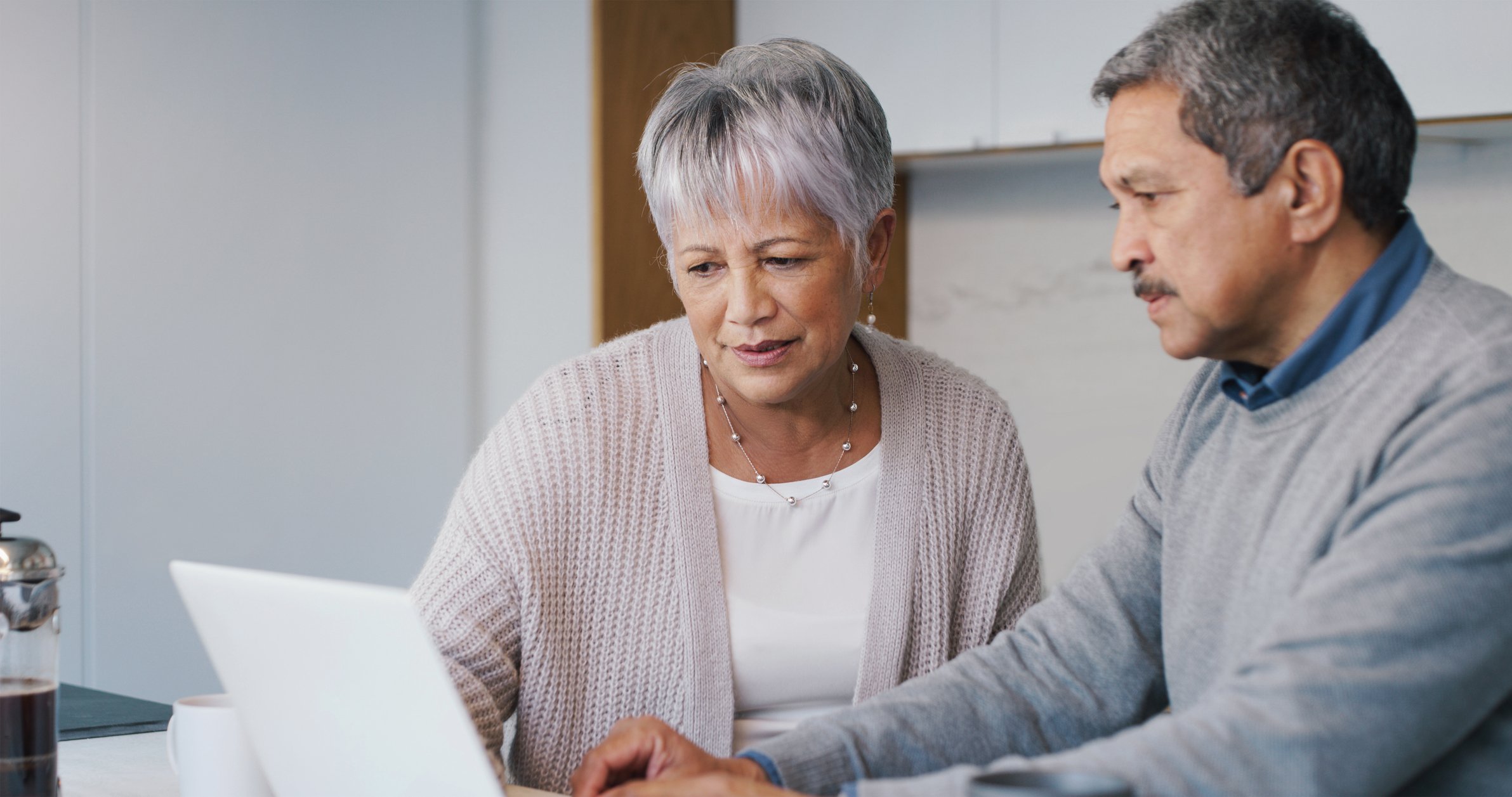 Two people looking at a laptop.