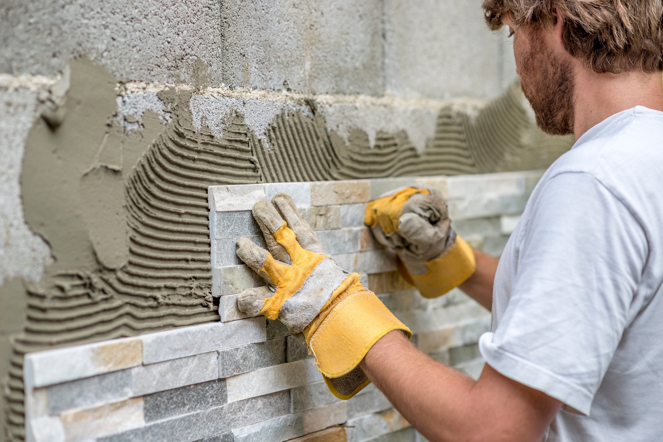 A contractor installs a wall treatment.
