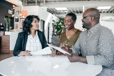 Three people looking at papers Getty