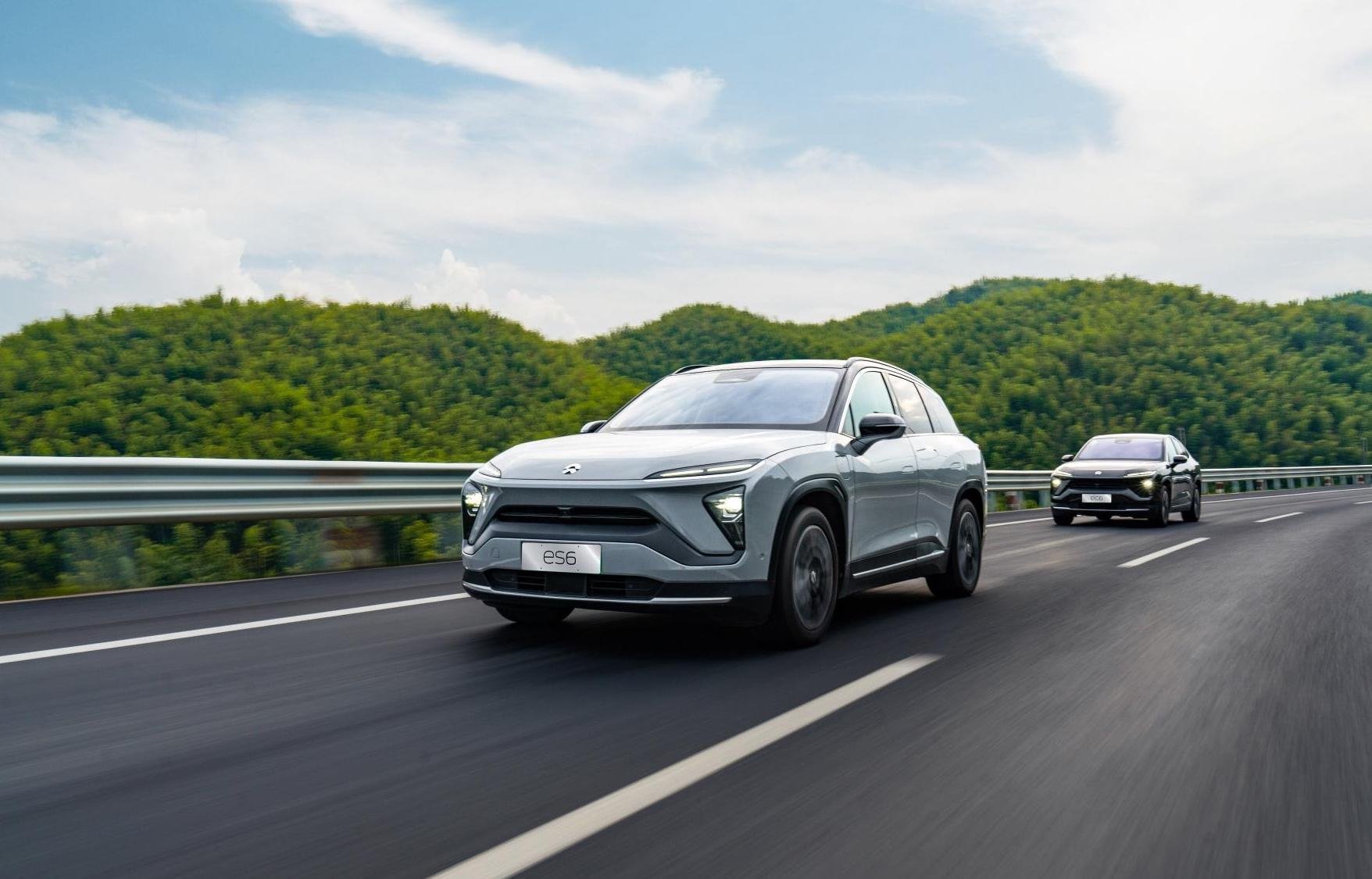 A NIO ES6, an upscale five-passenger electric SUV, is shown leading a NIO EC6 on a mountain road. 