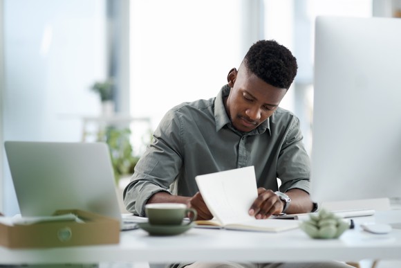 Businessperson at desk taking notes. 