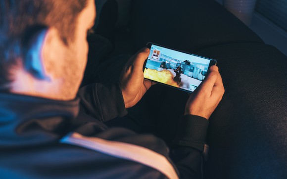 Person playing a mobile game on their smartphone.