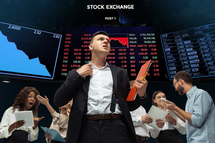 A person in front of a stock board showing the  market declining.