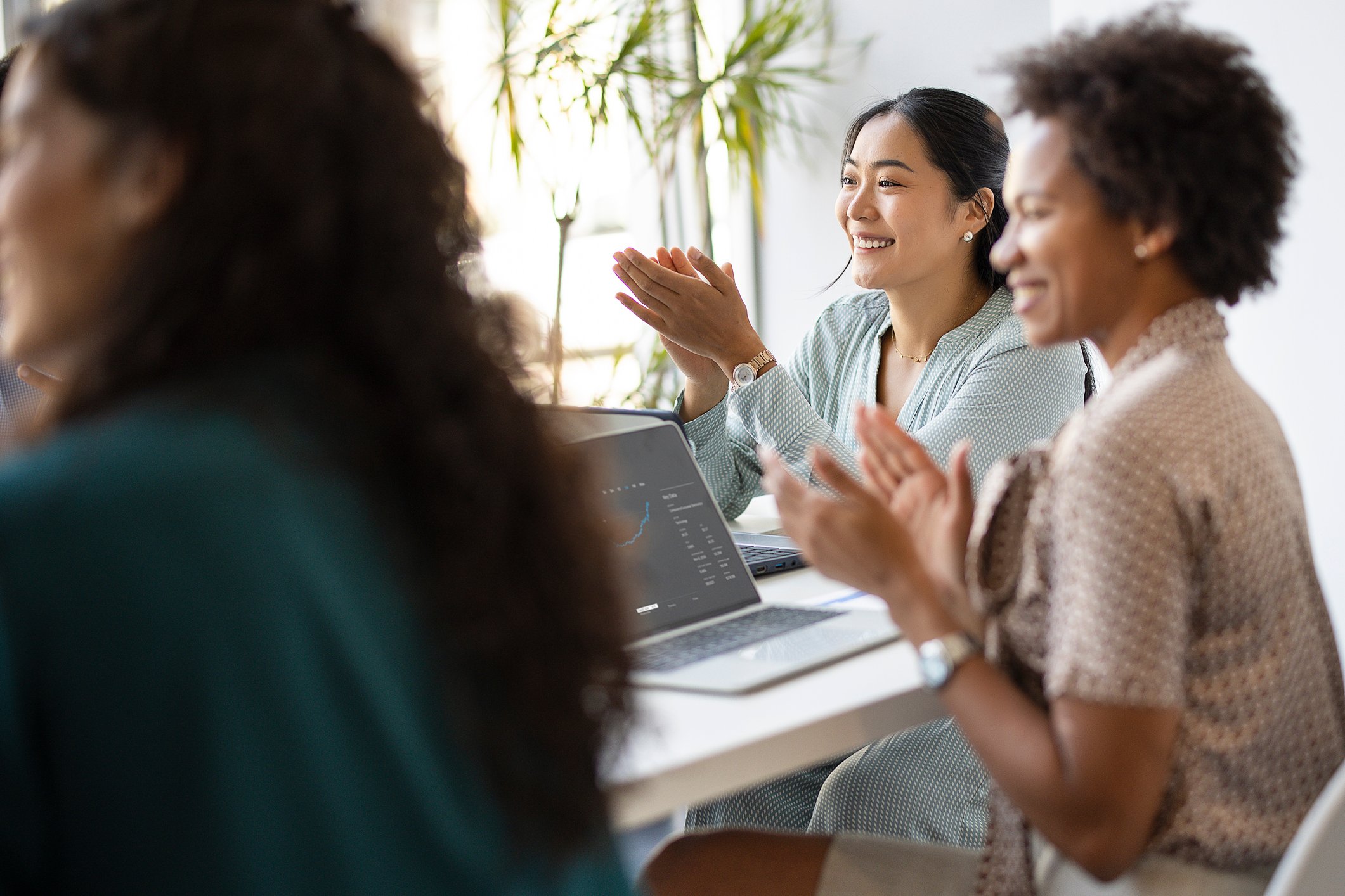 Colleagues clap during a meeting.