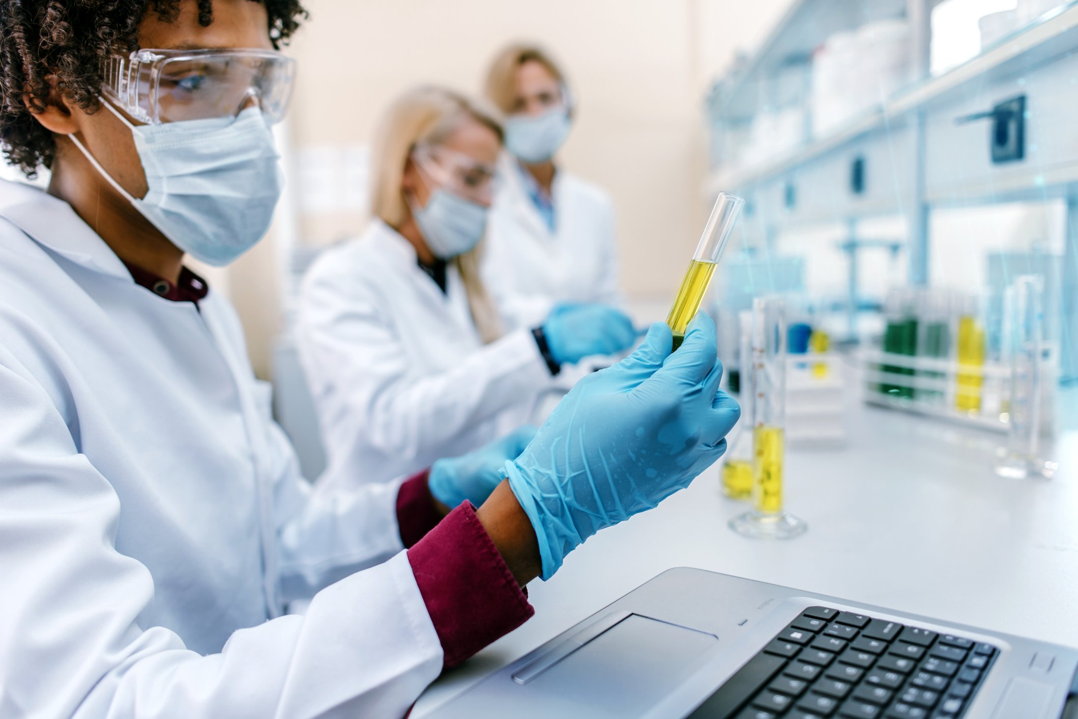 Pharmaceutical lab technician examining liquids.