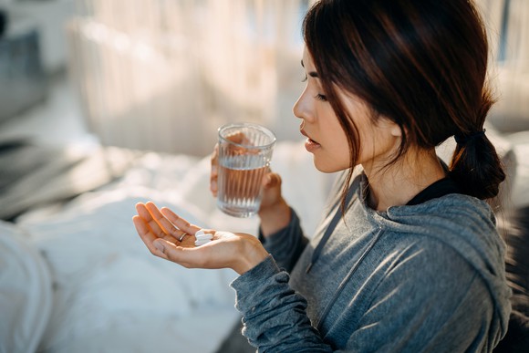 A woman about to take medicine.