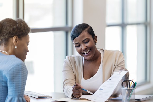 Two people reviewing an application form.