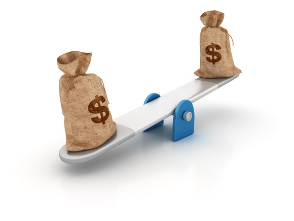 Seesaw with two money bags on each end.