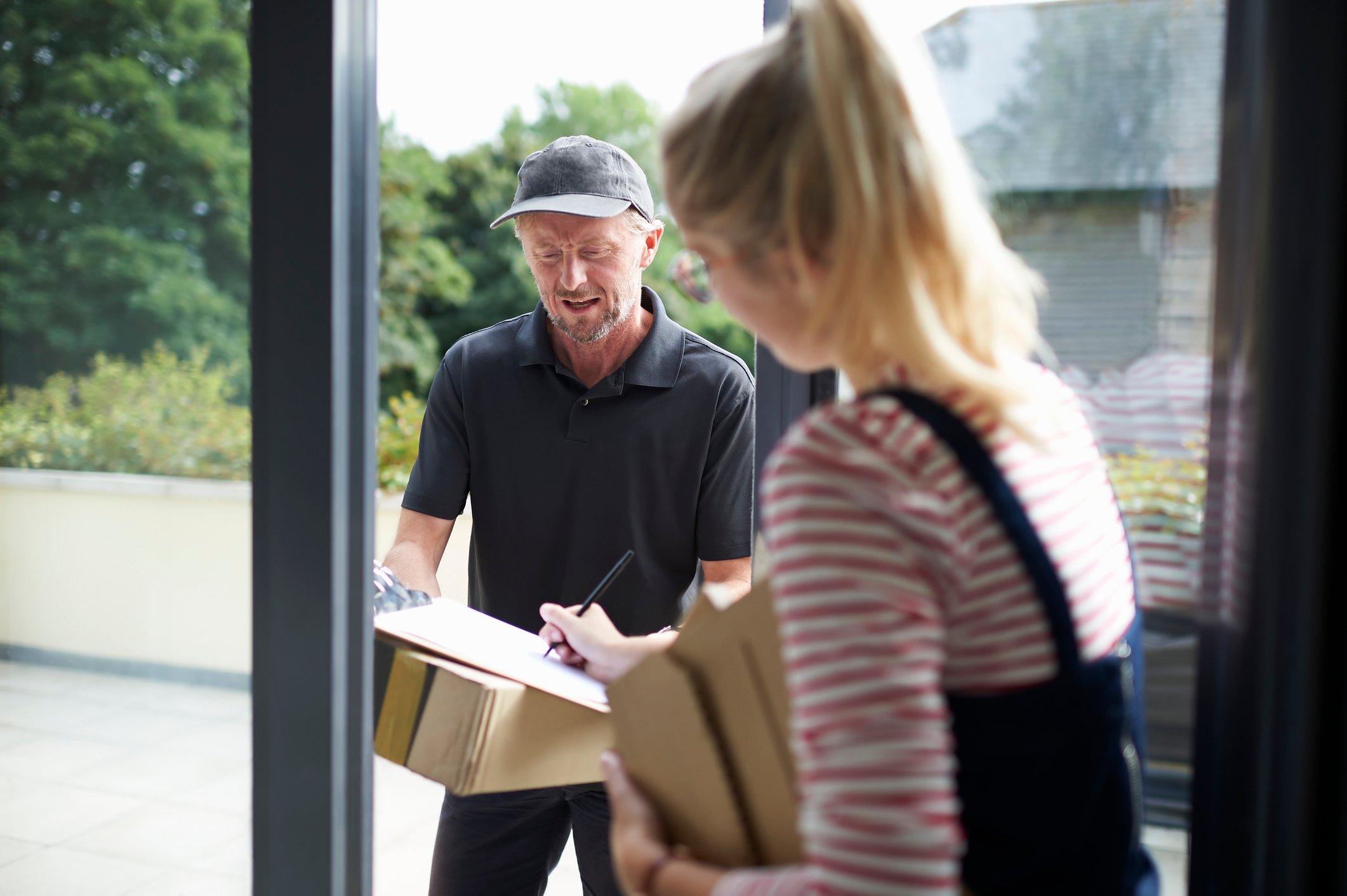 A delivery driver drops off a box at a customer's door.