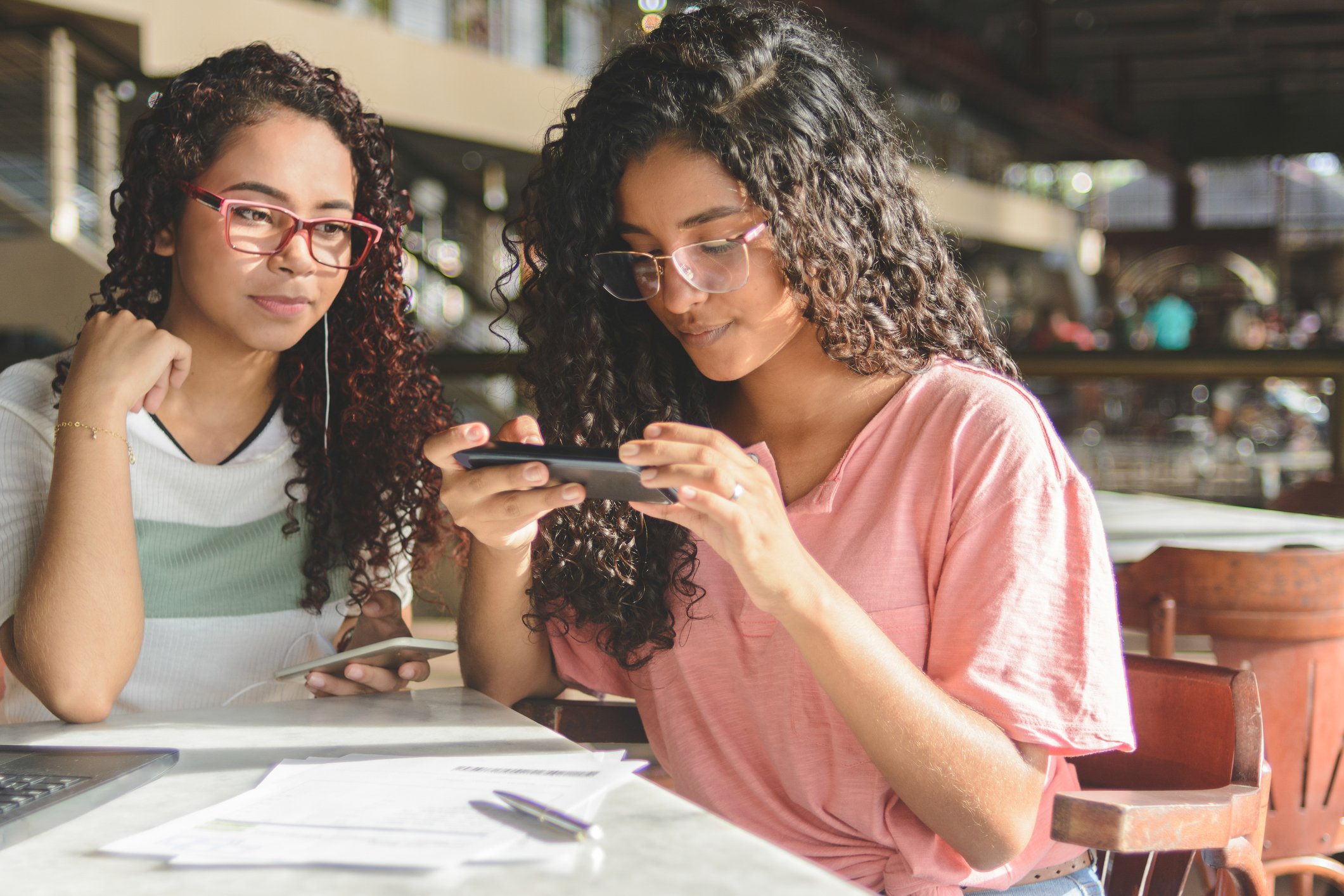 Two women scanning a bill into a digital bank app.