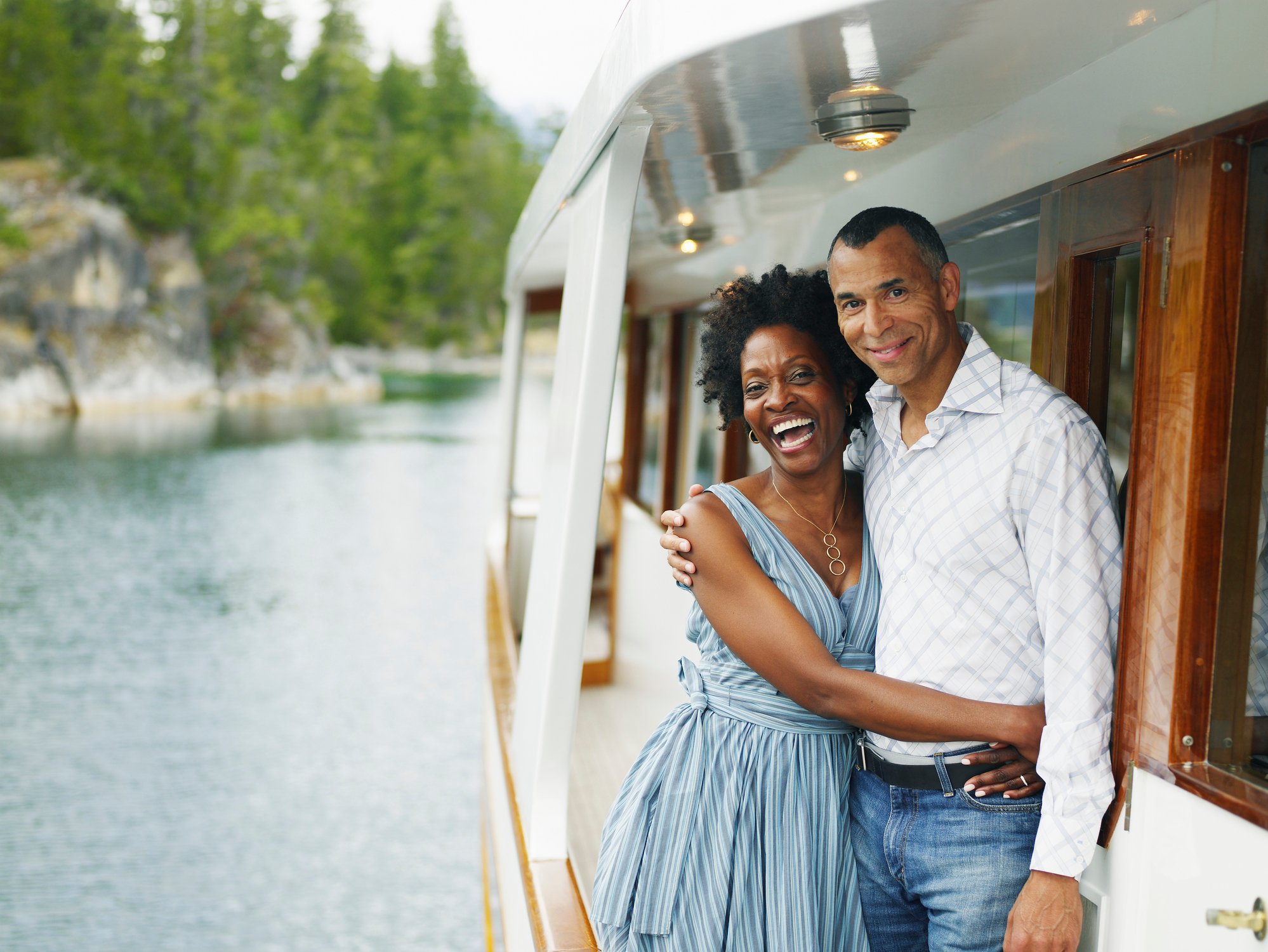 A couple is embracing on a yacht.