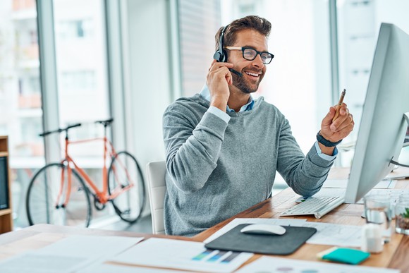 Sales agent working with HubSpot CRM while facing a computer screen.