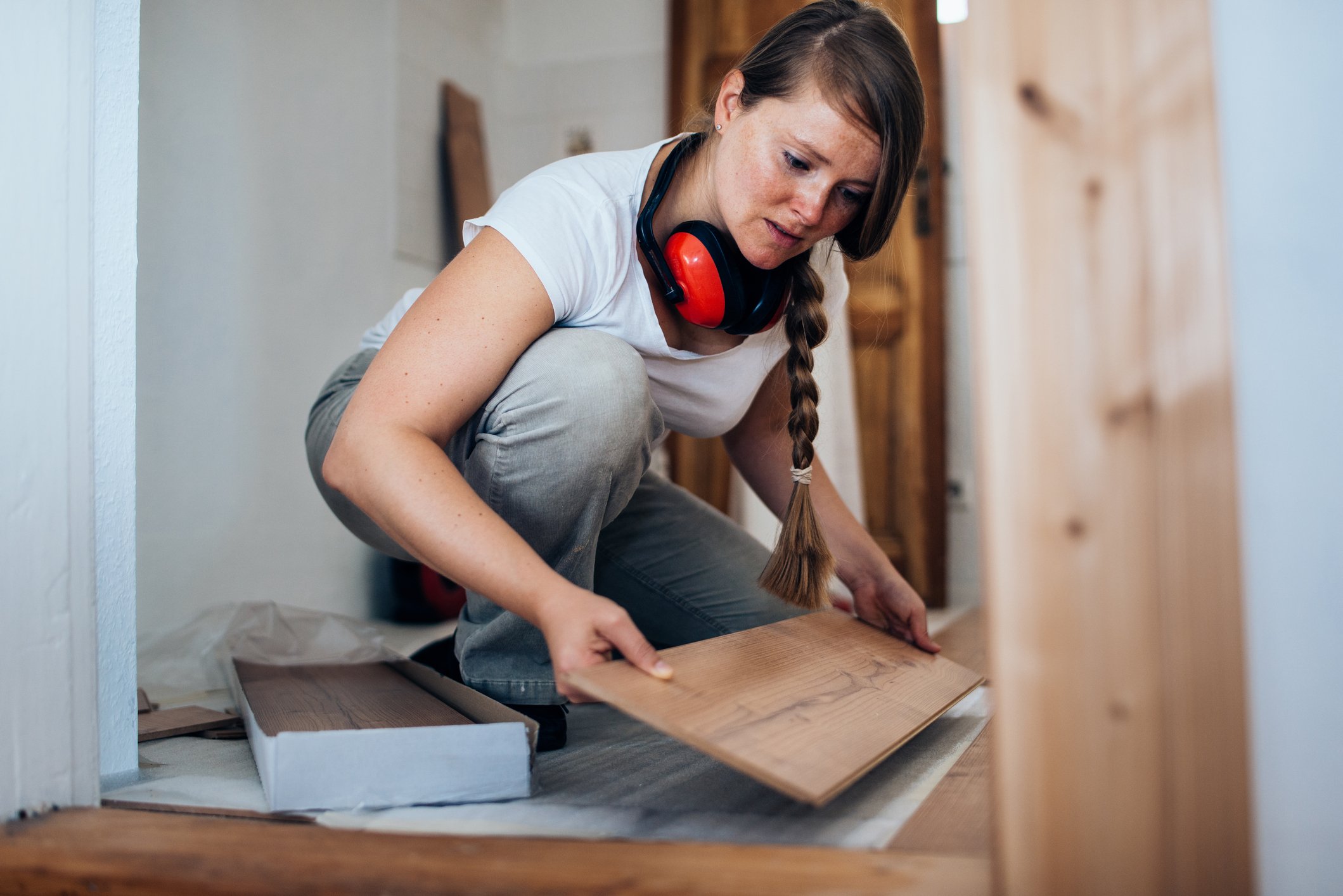 A person is installing hardwood flooring. 