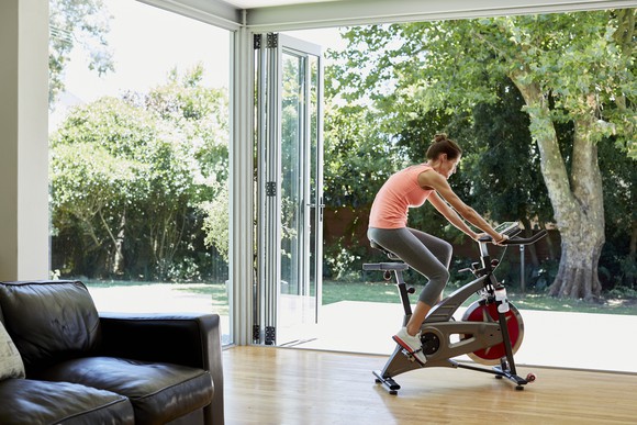 A person exercising on a stationary bike inside a home. 