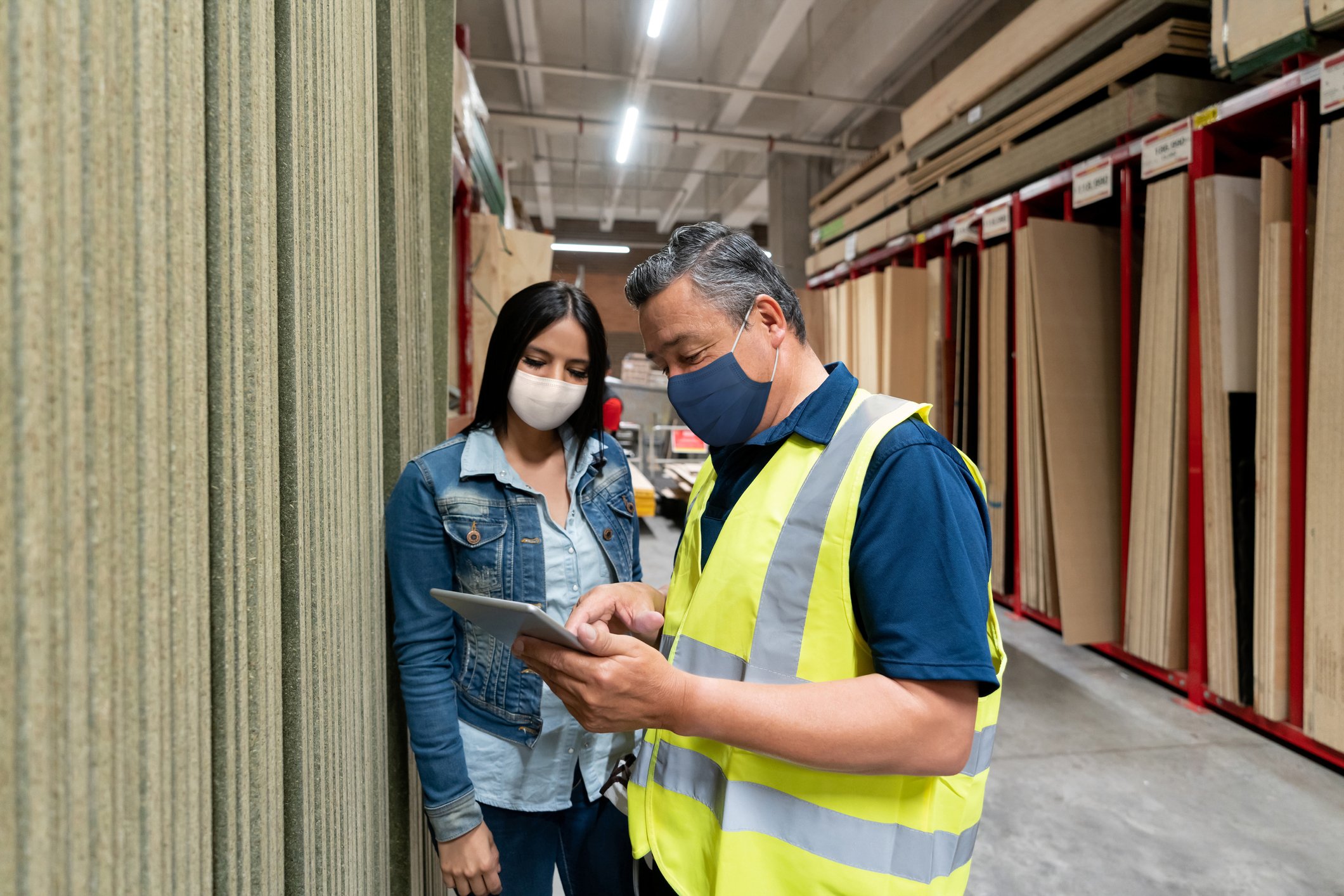 Two people in a hardware store looking at a tablet.