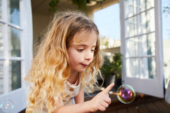 A child about to pop a bubble.