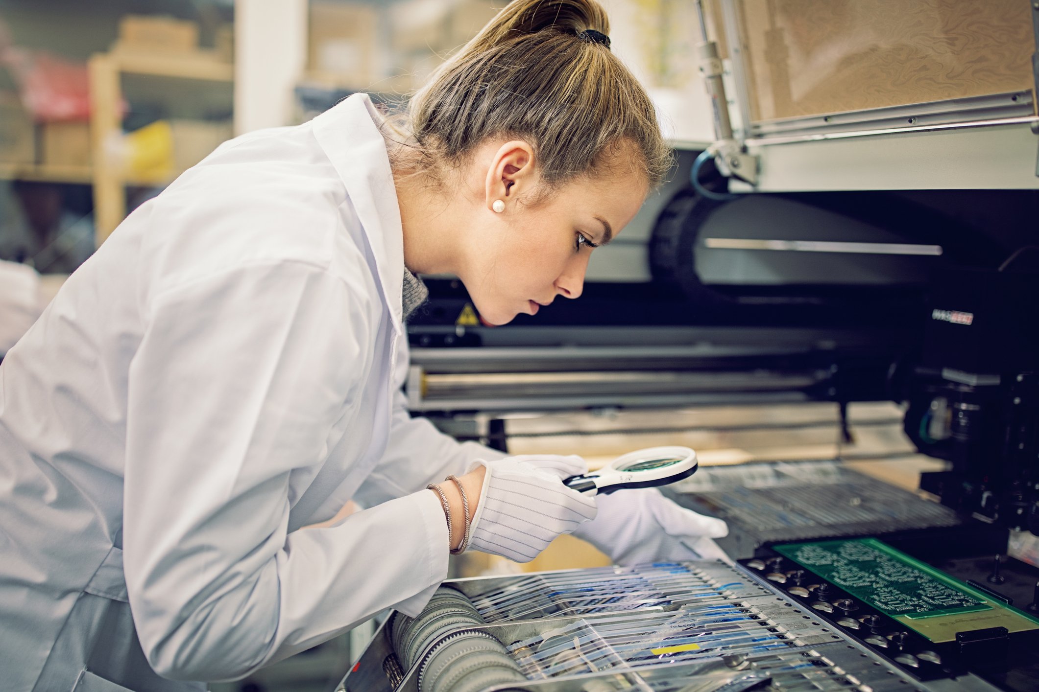 Technician examining semiconductor chips in a factory setting.