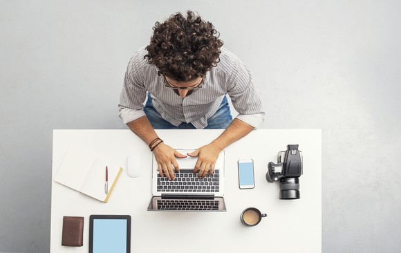 Person working on a computer at a neat table. 