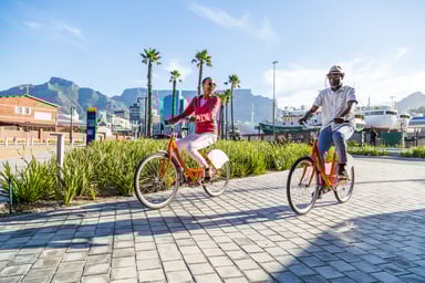 A man and woman ride bicycles.