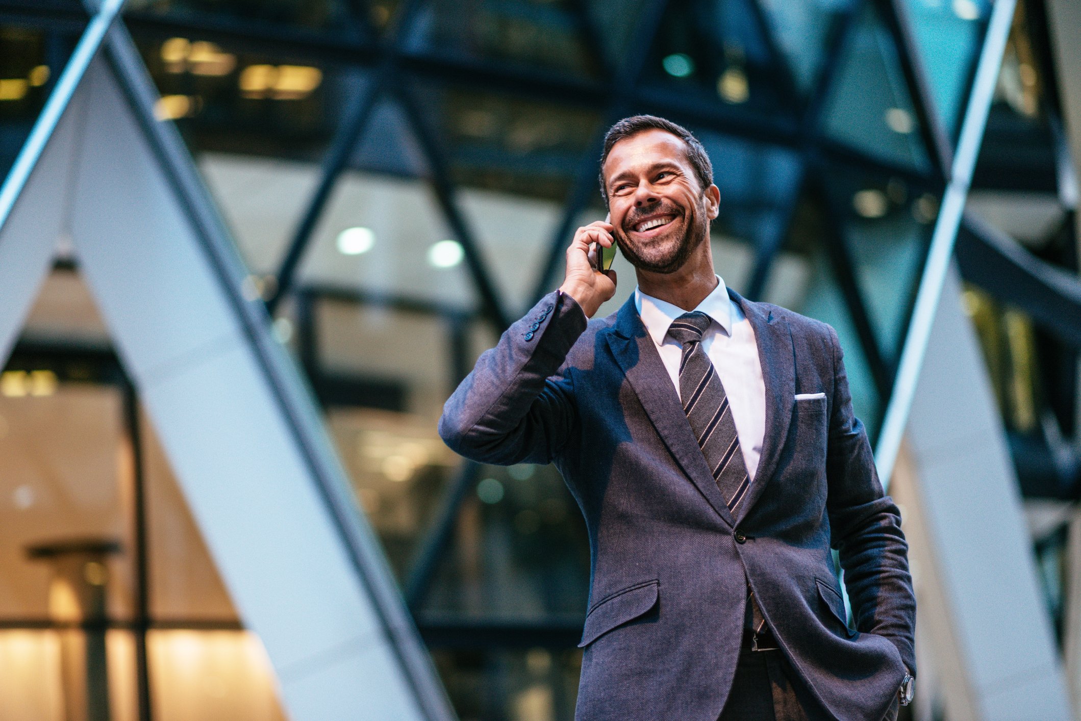 businessman in suit smiling and talking on the phone