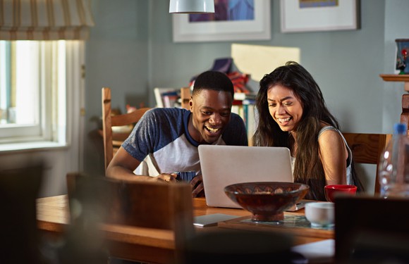 excited young couple looking at laptop screen