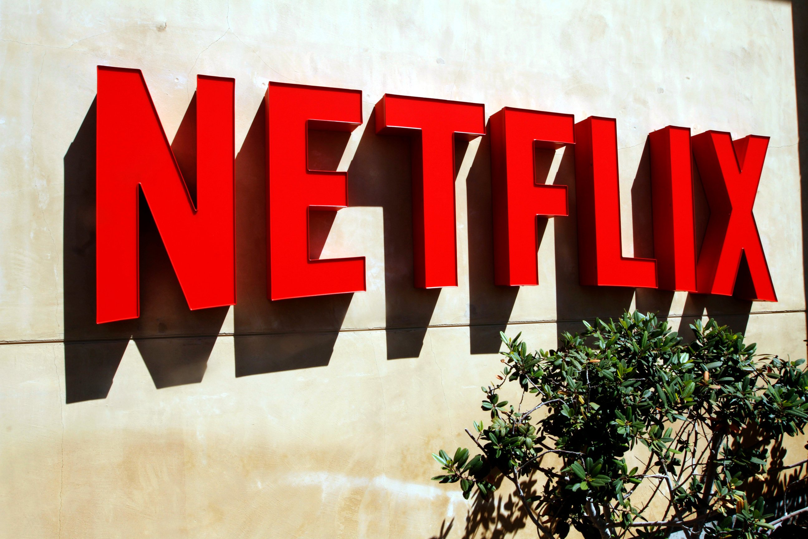 Red Netflix logo on a beige stucco wall.