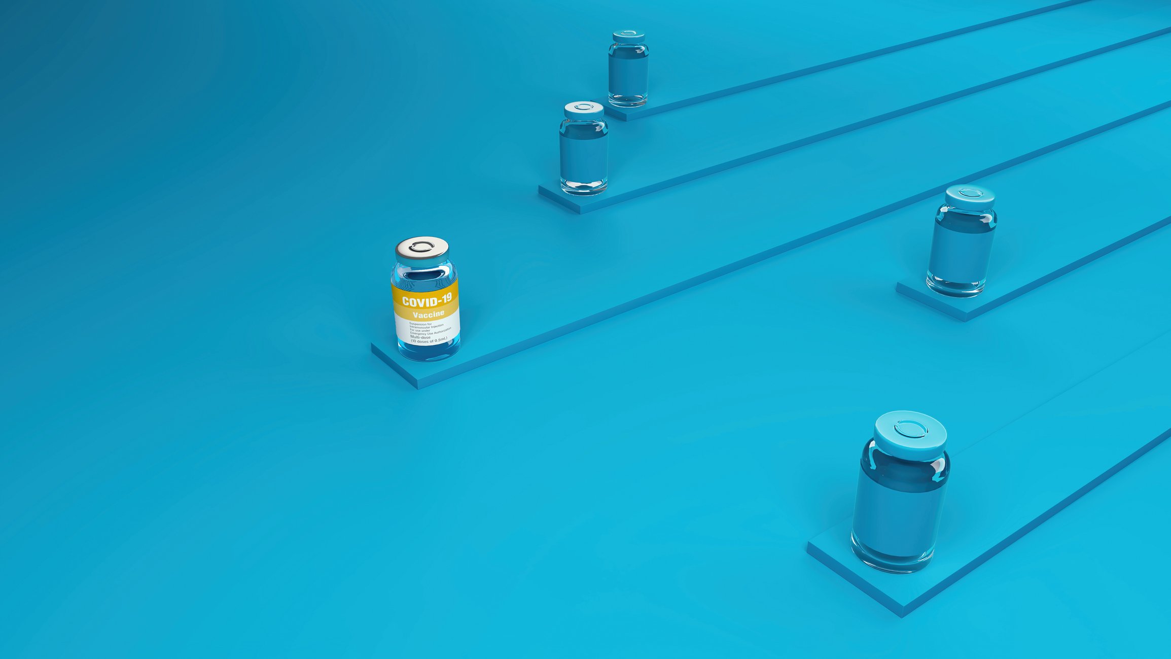 Four COVID-19 vaccine vials colored blue with one vial with an orange and white label in front of the others.