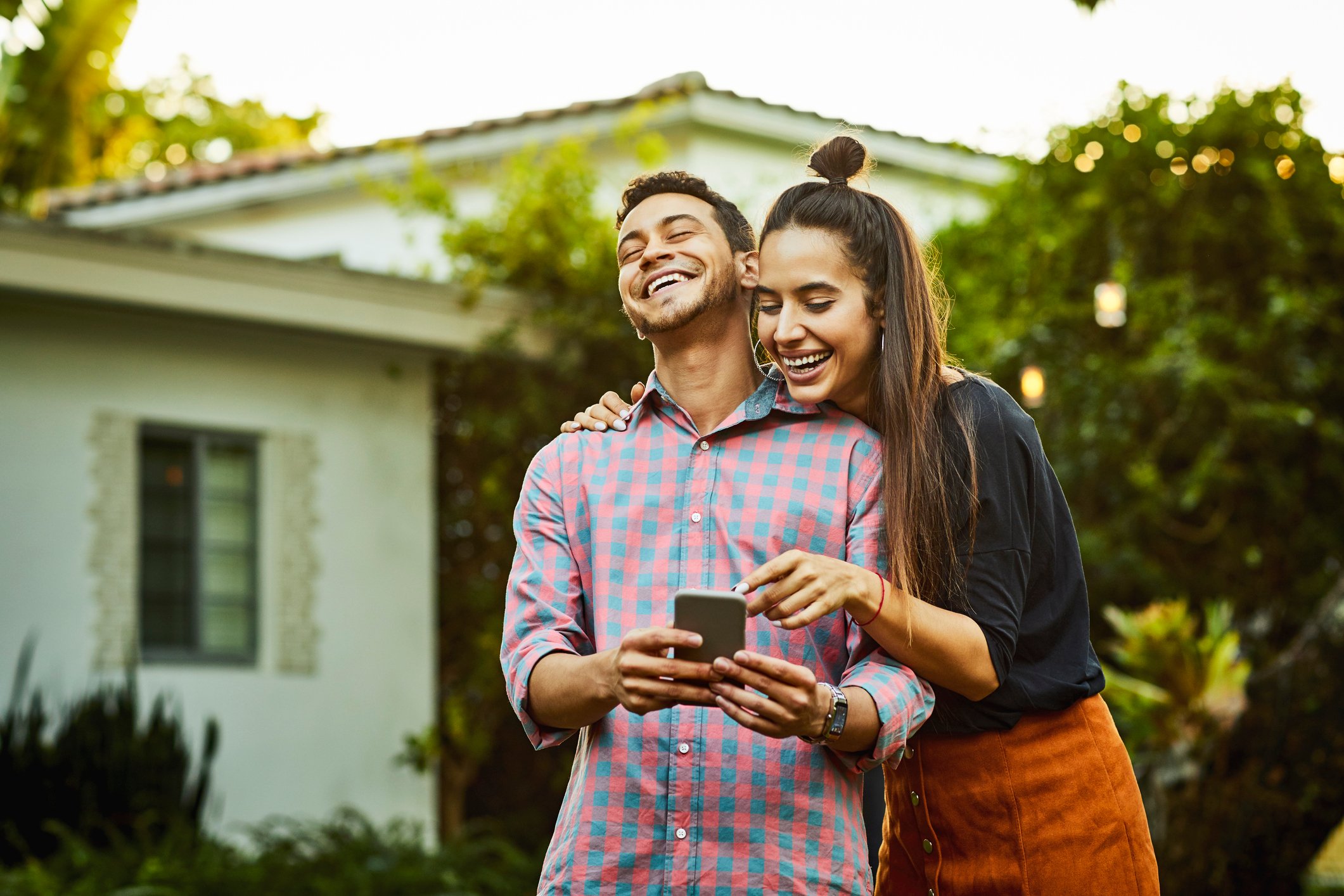Happy young couple looking at a mobile phone