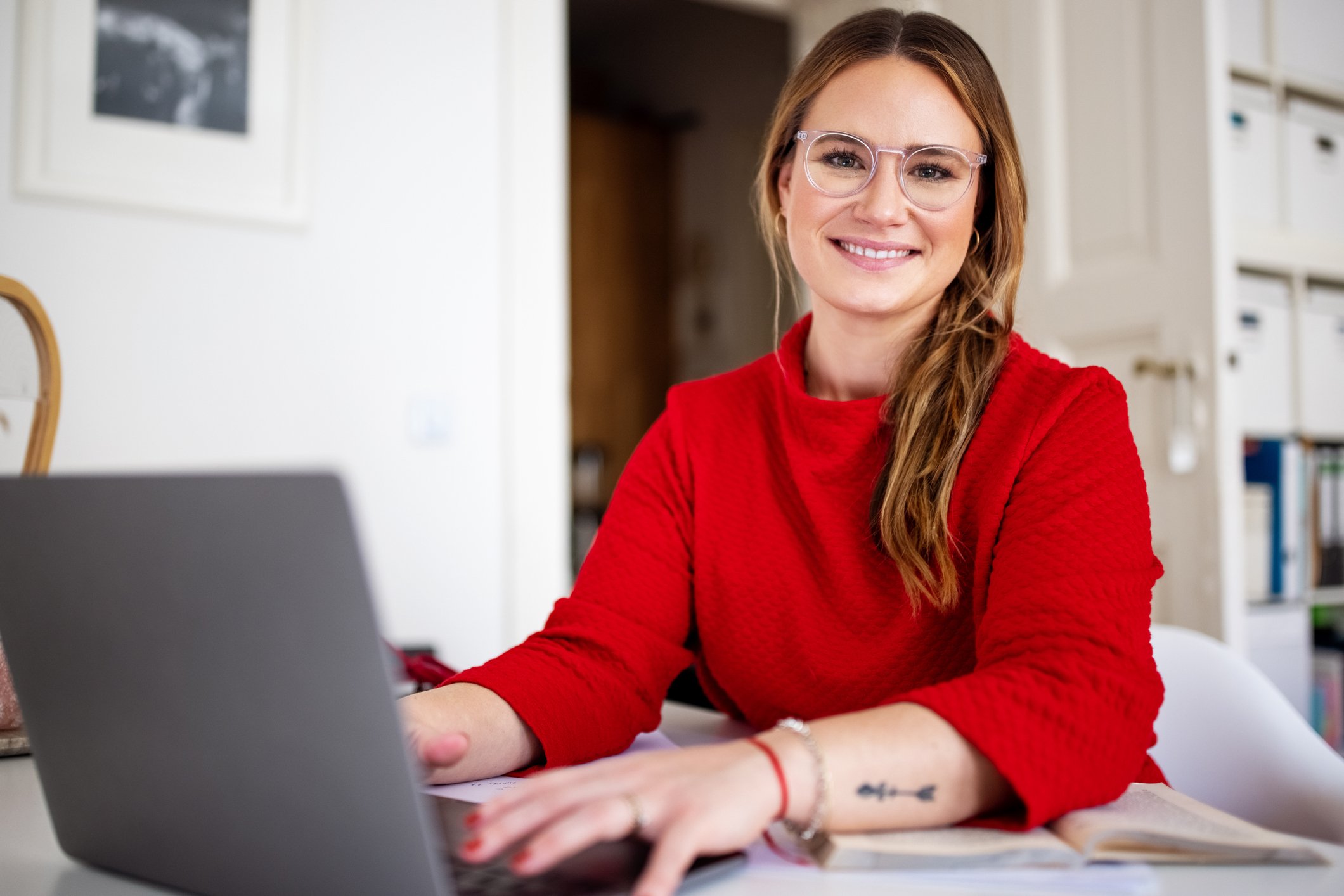 young businesswoman smiling and sitting at laptop
